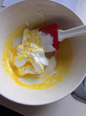 用刮刀刮起1/3的蛋白霜，放于蛋黄中，上下翻拌至大致均匀