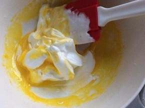 用刮刀刮起1/3的蛋白霜，放于蛋黄中，上下翻拌至大致均匀