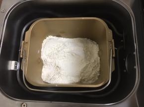 然后放入粉类，盐和糖对角放，酵母放中间，用面粉盖上。启动面包机和面功能，开始工作。