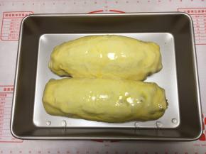 把发酵好的大面包的表面刷上全蛋液。