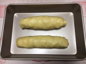 把卷好的大面包放在烤盘里。 注意两个大面包卷的间距，太近了，发酵后就容易粘在一起。