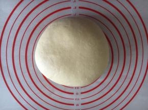 拿出发酵好的面团排气，盖上保鲜膜餳15分钟。