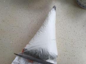 裱花袋装好花嘴，放入蛋白（可以用筷子沾点色粉，往裱花袋边上插进去）