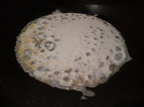 不粘锅放适量油，把番薯粉水倒入锅中央，像摊鸡蛋饼一样