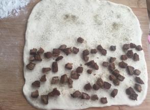 擀开成正方形薄片，一半的地方放牛肉粒，撒黑胡椒粉，然后把另一半盖上。