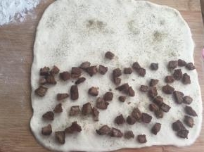 擀开成正方形薄片，一半的地方放牛肉粒，撒黑胡椒粉，然后把另一半盖上。