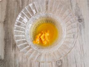 称取玉米油和南瓜泥蜂蜜倒入碗中。并用打蛋器混合搅拌至充分乳化的状态。