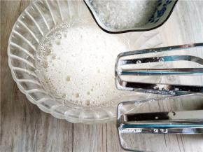 柠檬滴入蛋白，用打蛋器打至鱼泡眼。