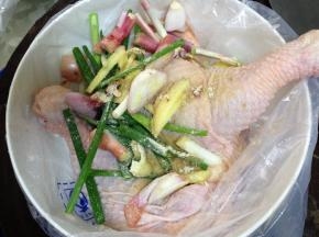 把鸡腿放入塑料袋，加葱、姜、洋葱、白胡椒粉、料酒