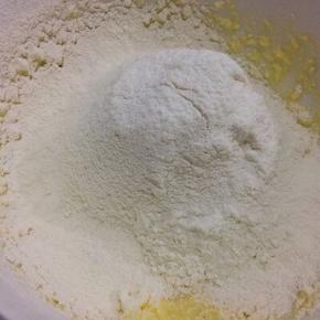 把面粉和泡打粉筛入混合均匀的黄油鸡蛋液中
