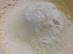把面粉和泡打粉筛入混合均匀的黄油鸡蛋液中
