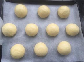 松弛后再次擀开排气，然后搓圆，放入烤盘。入烤箱发酵，烤箱里放碗热水。