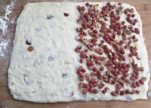 擀开成18*28cm的长方形，一半9*28处铺满切成半个的花生。然后把另一半盖上