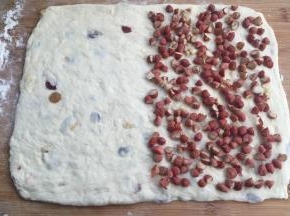 擀开成18*28cm的长方形，一半9*28处铺满切成半个的花生。然后把另一半盖上