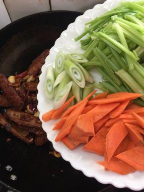 加入芹菜，胡萝卜和葱白翻炒至断生！