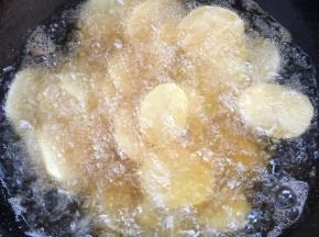 把沥干水分的土豆片，一片一片的放入锅中进行炸制！