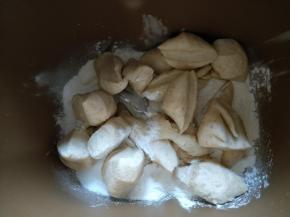 面包机放入主面团材料，再将中种面团剪成小块。启动揉面程序30分钟。