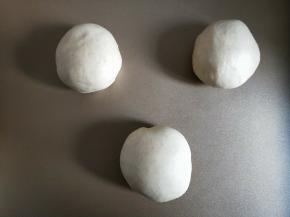 将面团放入烤箱进行发酵。旁边放一碗热水。