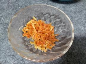 锅中倒入10-15g左右的油加热，把多一半控干水分的干贝丝放入锅里干煸，这里应该就明白为什么要控干水分，如果有水会溅的到处都是油，煸炒到出香味有点金黄就可以了盛出放一边