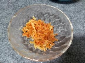 锅中倒入10-15g左右的油加热，把多一半控干水分的干贝丝放入锅里干煸，这里应该就明白为什么要控干水分，如果有水会溅的到处都是油，煸炒到出香味有点金黄就可以了盛出放一边