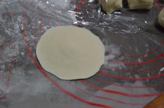 取一个小剂子擀圆，中间厚四周薄