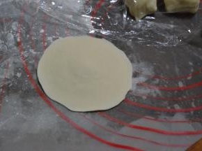 取一个小剂子擀圆，中间厚四周薄