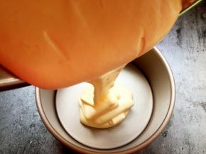 将拌好的蛋糕液倒入模具中。拌好的蛋糕液如丝带飘落。