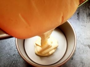 将拌好的蛋糕液倒入模具中。拌好的蛋糕液如丝带飘落。