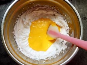 将蛋黄糊倒入蛋白中，以画Z或画J的手法翻拌均匀。