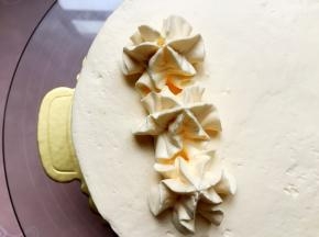 在蛋糕表面挤上奶油花。