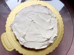 将一片蛋糕放在垫板上，均匀抹上奶油。