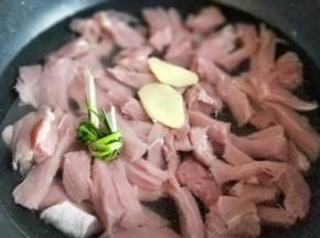 切好的里脊肉放入锅中,加入清水,没过里脊肉为佳,加入切好的姜片,葱。