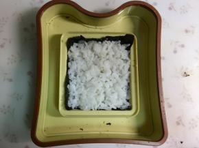 其中一张海苔放进模具里，盖上一层米饭