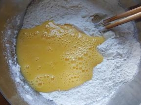 3．面粉中加入打散的蛋液和食用盐与白砂糖。