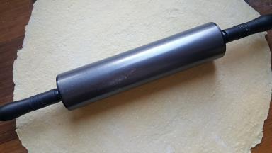 5．用擀面杖将面团擀成一个大的面皮。