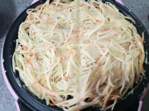 把土豆丝夹到煎盘上，填满，盖好盖子等着，我的机器大概煎了7分钟