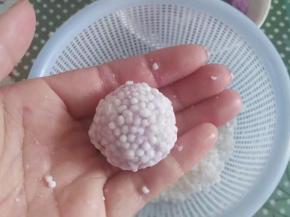 取一个紫薯球放在左手心，右手抓少许西米放在紫薯球上，然后轻轻的把西米捏在紫薯球上就可以啦；