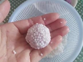 取一个紫薯球放在左手心，右手抓少许西米放在紫薯球上，然后轻轻的把西米捏在紫薯球上就可以啦；