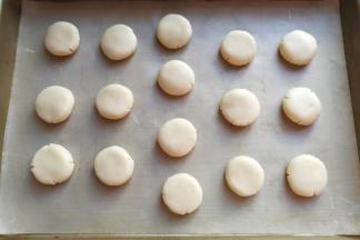 然后把圆面团摆入烤盘中，用手稍微压扁；