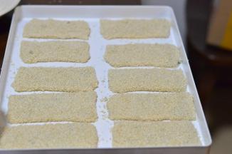 两面刷一点水，粘上芝麻，放入烤盘