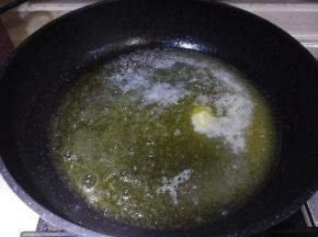 不沾平底锅放入黄油，燃气灶开小火，黄油融化成液态