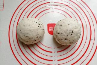 把发好的面团取出，挤压排气后分成均匀的两份滚圆，盖保鲜膜醒发15分钟；