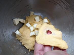 启动厨师机和面10分钟，至面团能拉出粗膜，加入盐和软化的黄油