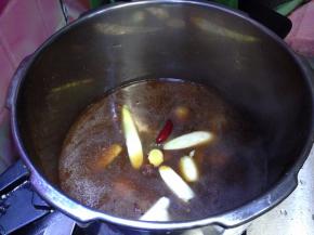 倒入高压锅，下入葱、姜、花椒、大料、辣椒，调入料酒（如果觉得颜色浅，可以加入适量老抽）加盖加阀烧至上气，上汽5分钟后转中小火25分钟后关火，自然泄气即可食用