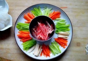 将青椒，胡萝卜，黄瓜，火腿肠切丝，摆盘，然后把肉切成细丝