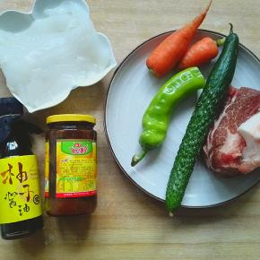 准备青椒20g 黄瓜一根 胡萝卜50g 肉100g 拉皮200g 豆瓣酱一勺 柚子酱油2勺 醋2勺 盐适量 火腿肠一根