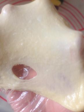 10、做餐包 到扩展阶段就可以 喜欢拉膜的话 可以切一块下来 拉开就是这样 厚的膜 戳个洞 不是很光滑  如果做吐司 还需要继续揉