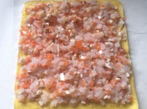 取出蛋皮，铺上搅拌好的虾仁馅，下面留一厘米的空