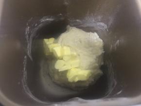 大约20分钟，面团基本揉至光滑后加入软化的黄油继续揉。