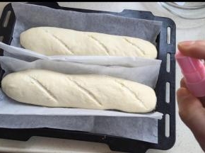 用油纸搬到烤盘上，烤箱30度发酵60分钟。拿出，割花纹。烤箱预热上下火230度（简易预热好了再割花纹，我割得太早，又闭合了）